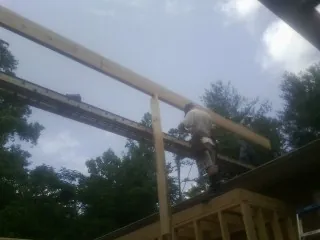 Carpenter setting a ridge beam over a new addition frame — Ice Dam Removal by Roofing Brothers in Glide