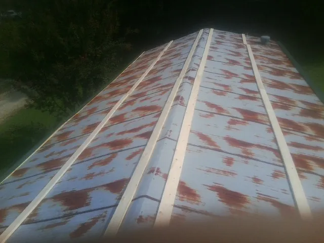 Rusted metal roof panels with new wood purlins before replacement — Storm Damage Roof Repair in Glide by Roofing Brothers