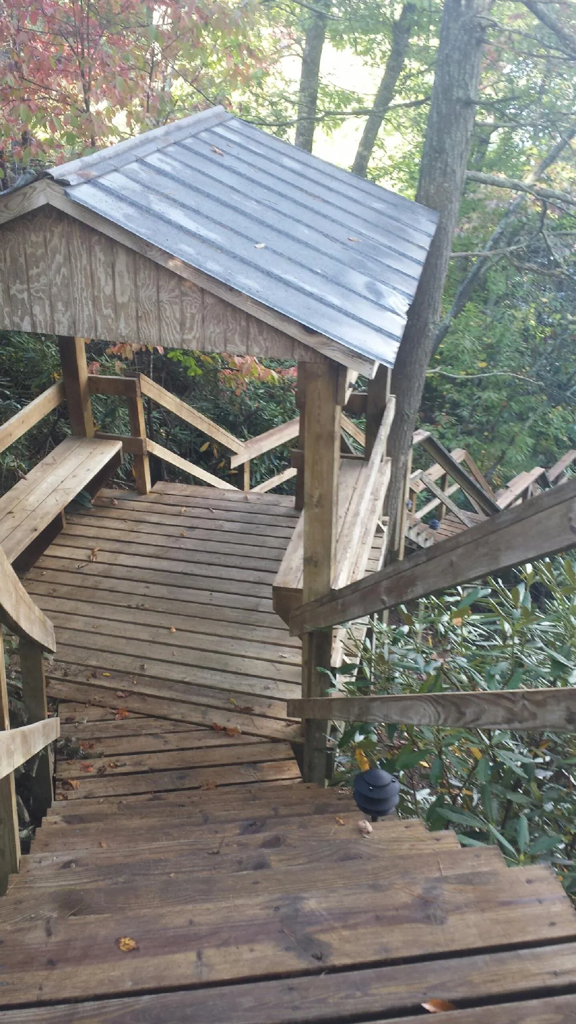 Metal roofed shelter over wooden steps on a wooded walkway — Skylight Repair & Installation work by our crew in Glide