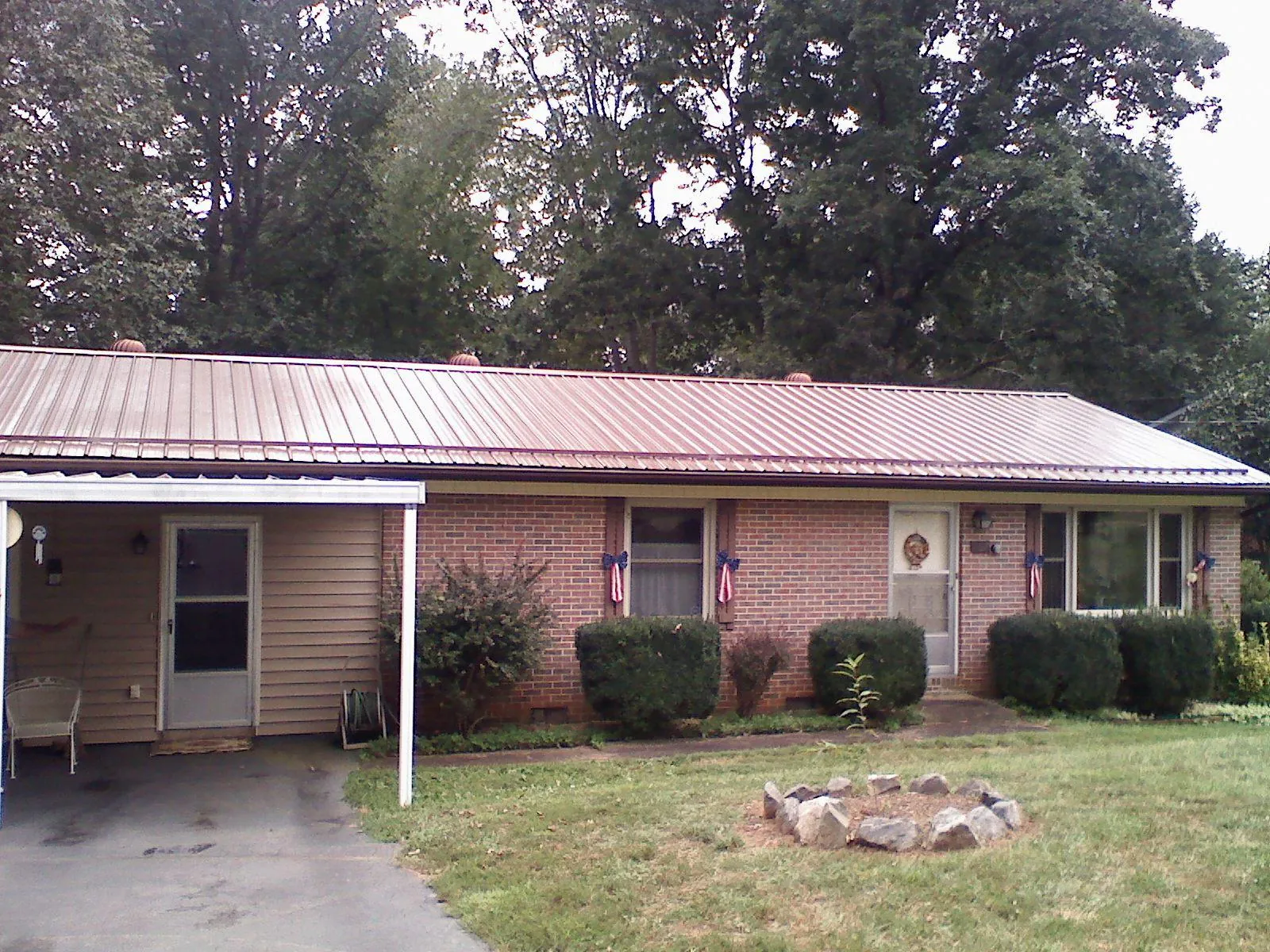 Bronze metal roof and carport on a brick ranch home — Roof Repair work by our crew in Glide