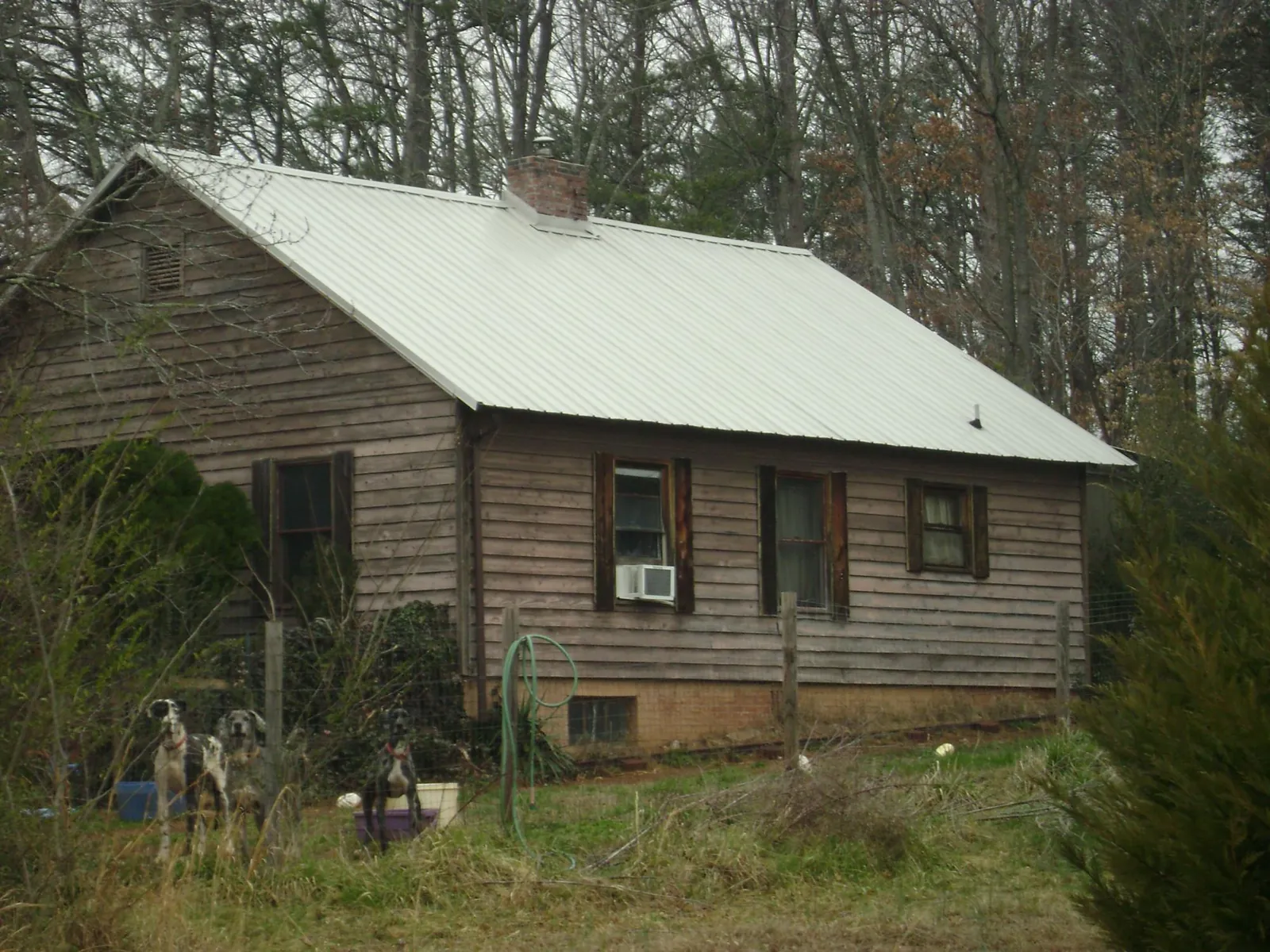 White metal roof on an old wood sided farmhouse, from a Metal Roof Installation job in Glide
